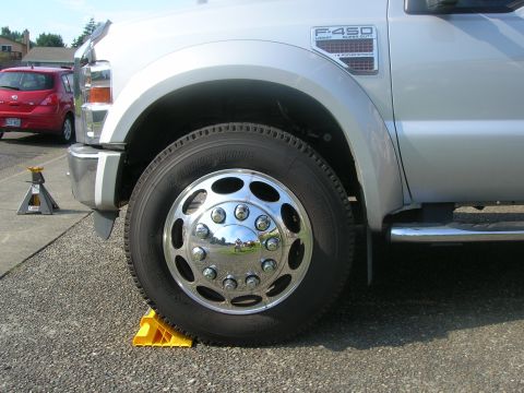 2008 Ford F-450 - Silver 2008 Ford F-450 Super Duty truck front wheel and fender detail, parked on wheel chocks.
