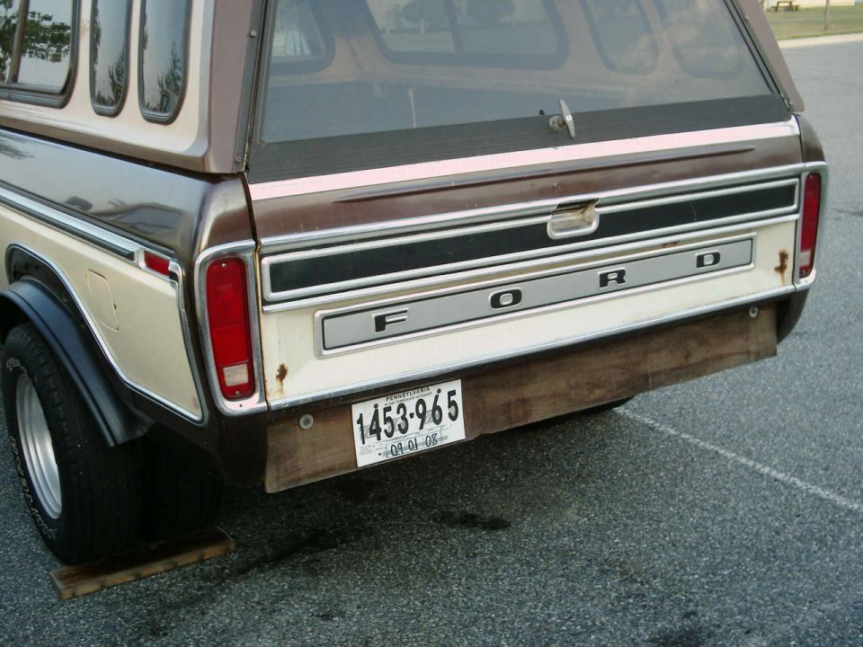 Rear tailgate of a Ford truck with camper shell and license plate