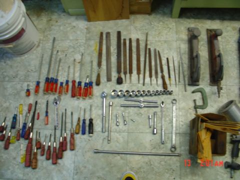 1985 Ford Bronco - Various hand tools including screwdrivers, ratchets, and files are organized on a floor.