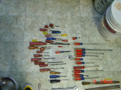 1985 Ford Bronco - A collection of various hand tools, including screwdrivers and a wrench, are laid out on a tiled surface.