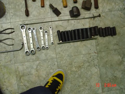 1985 Ford Bronco - A collection of various tools, including wrenches and socket set, are arranged on a tiled floor.