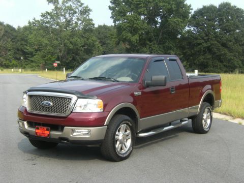 2005 Ford F-150 - This maroon and tan Ford F-150 pickup truck is shown from a three-quarter front view, parked outdoors.