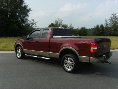 2005 Ford F-150 - This maroon and tan Ford F-150 pickup truck is viewed from a 3/4 rear angle.