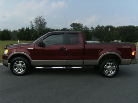 2005 Ford F-150 - This maroon and tan Ford F-150 pickup truck is shown from the side, equipped with a toolbox.