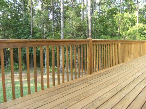 1992 Ford F-150 - A wooden deck with a railing overlooks a wooded area, with a watermark visible in the lower right corner.