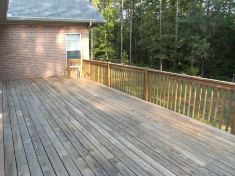 1992 Ford F-150 - A wooden deck extends from a brick house, surrounded by trees. The image includes a watermark for SuperMotors.net.