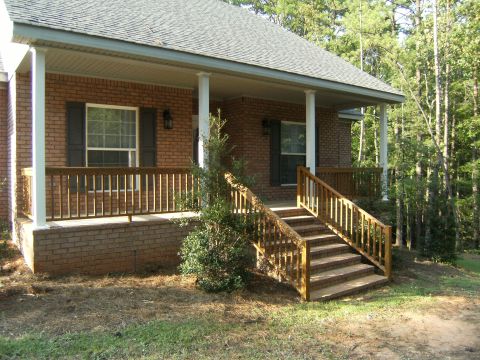 1992 Ford F-150 - A view of a house's entrance, a brick facade, wooden railings, and stairs leading up to the porch.