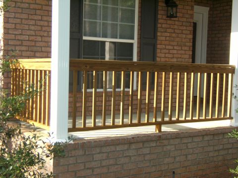 1992 Ford F-150 - A wooden porch railing is shown in front of a brick house with a white column and a window.