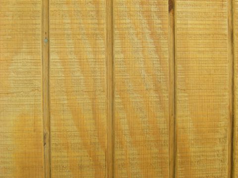 1992 Ford F-150 - Extreme close-up of rough-sawn, freshly stained vertical wood siding or deck boards showing the grain, saw marks and grooved seams between…