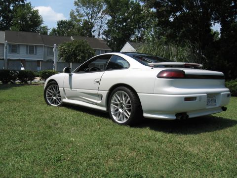 1992 Dodge Stealth - A white sports car is parked on a grassy lawn with houses in the background.