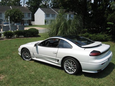 1992 Dodge Stealth - A white 1992 Dodge Stealth RT/TT is parked on a grassy lawn in front of residential buildings.