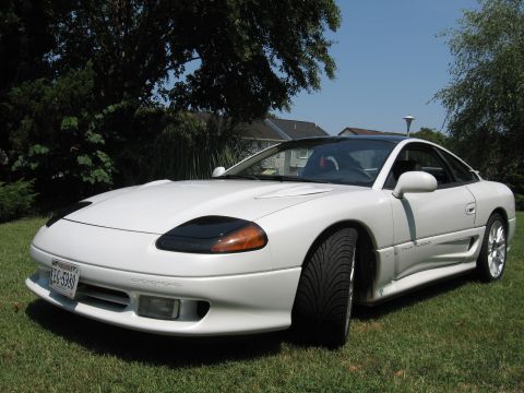 1992 Dodge Stealth - White 1992 Dodge Stealth sports car with black roof and tinted windows sits on a lawn.