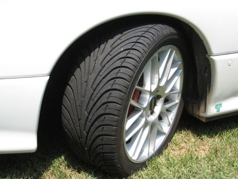 1992 Dodge Stealth - A close-up view of a car's wheel and fender shows a performance tire and a multi-spoke alloy rim.