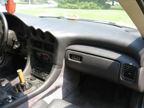 1992 Dodge Stealth - The dashboard and center console of a 1992 Dodge Stealth are visible, with a red leaf air freshener hanging from the rearview mirror.