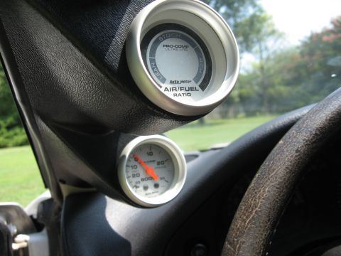 1992 Dodge Stealth - Two gauges are mounted on the dashboard of a vehicle, showing air/fuel ratio and another reading.