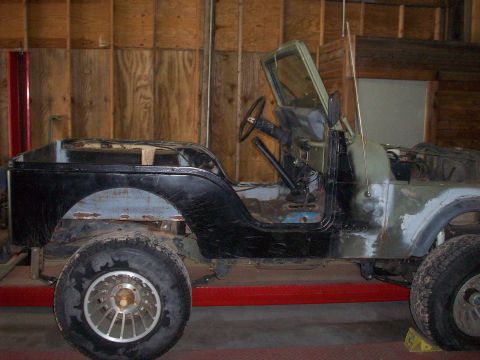 1978 Jeep CJ5 - This 1978 Jeep CJ5 is in a workshop, showing its side profile with exposed metal and partial paint.