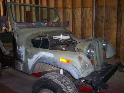 1978 Jeep CJ5 - Olive green 1978 Jeep CJ5 in a garage, showing the front 3/4 view with the hood open.