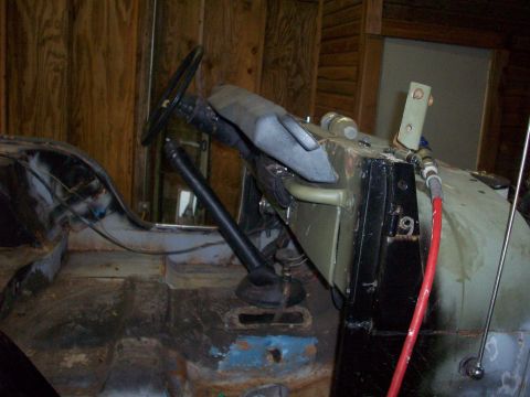 1978 Jeep CJ5 - The interior of a Jeep shows its dashboard, steering wheel, and floor panels, with visible signs of wear and tear.