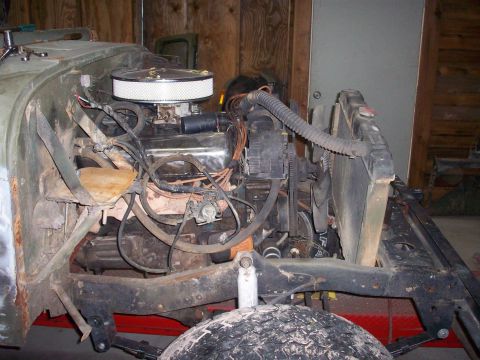 1978 Jeep CJ5 - The engine bay of a Jeep CJ5 shows its V8 engine and associated components, with the radiator and front suspension visible.