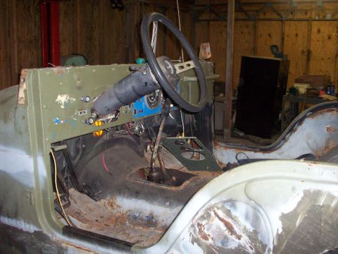 1978 Jeep CJ5 - Interior view of a 1978 Jeep CJ5, showing the dashboard, steering wheel, and floor. The vehicle is in a workshop setting.