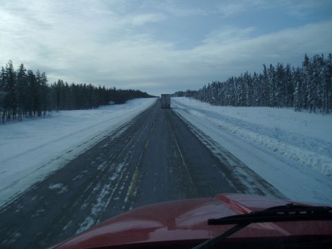 1995 Mercury Grand Marquis - View from inside a red vehicle driving on a snow-covered highway, with another truck visible in the distance.