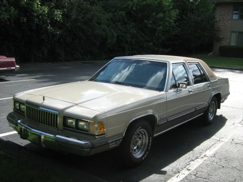 1988 Mercury Grand Marquis - A 1988 Mercury Grand Marquis sedan is seen parked outdoors, with another vehicle in the background.