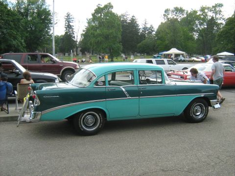 1988 Mercury Grand Marquis - A two-tone green and teal 1956 Chevrolet sedan is parked at an outdoor event with other vehicles visible.