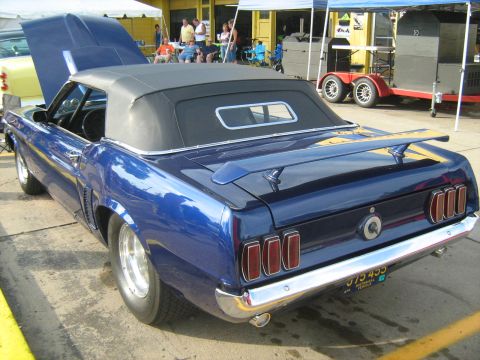 1988 Mercury Grand Marquis - A blue 1969 Ford Mustang convertible is parked with its hood open, displaying its rear end and spoiler.