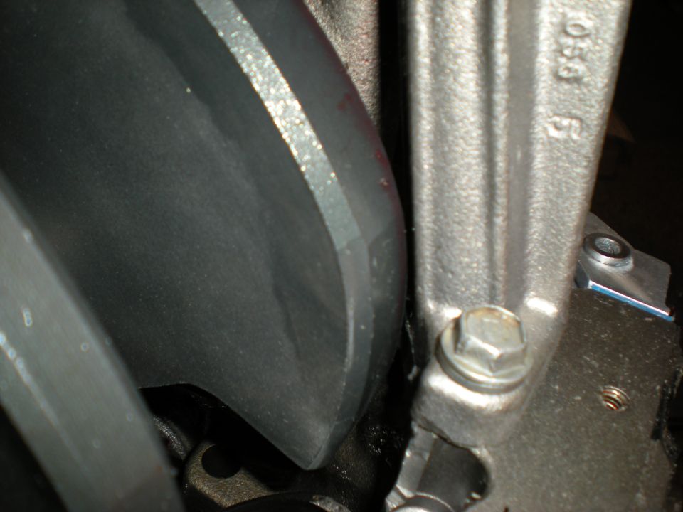 Close-up of a metal engine component with casting numbers '056' visible