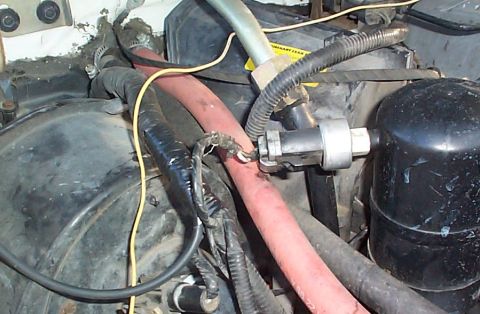 1992 Ford Bronco - Close-up view of various engine components and wiring within a vehicle's engine bay.