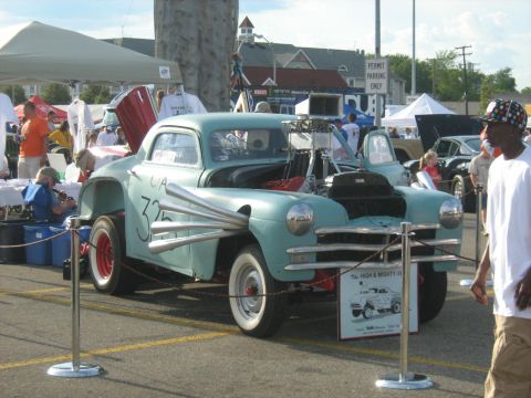 1988 Mercury Grand Marquis - Custom hot rod with exposed engine and side pipes on display at an outdoor event.