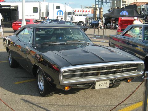 1988 Mercury Grand Marquis - A black 1970 Dodge Charger is displayed at an outdoor event, with other vehicles and tents in the background.
