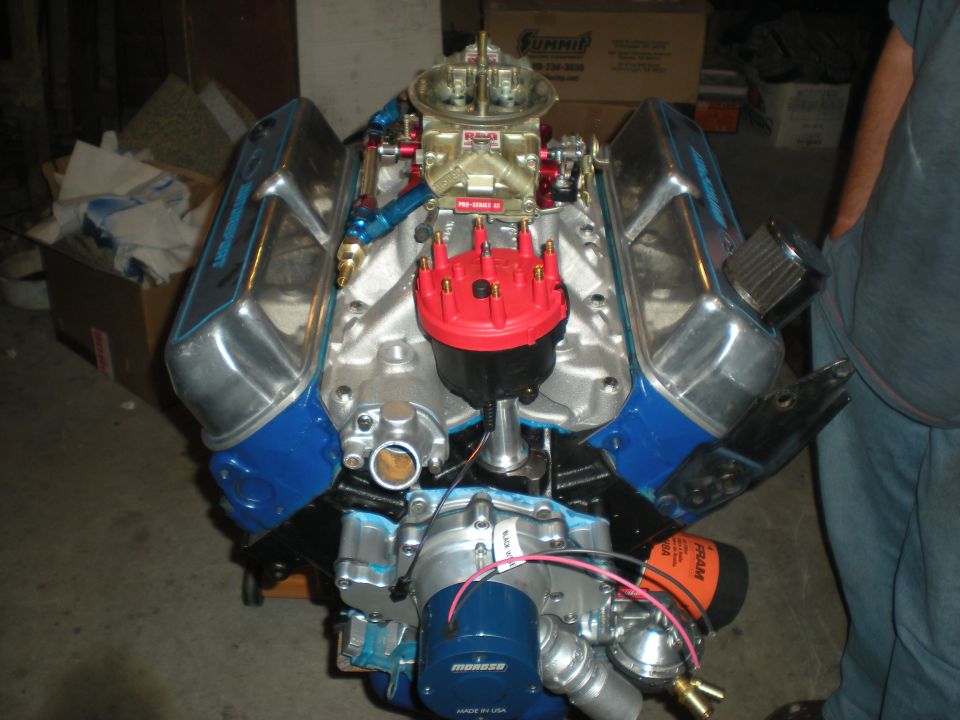 Engine with chrome valve covers and a red distributor cap, angled from the front