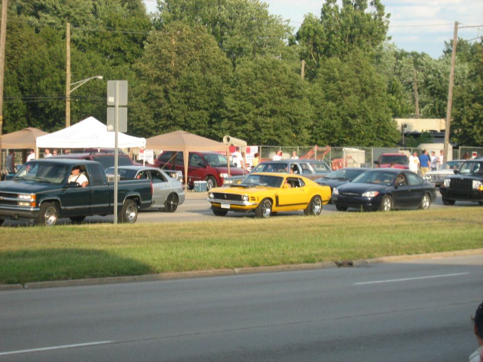Yellow Ford Mustang Boss-style fastback at a car cruise