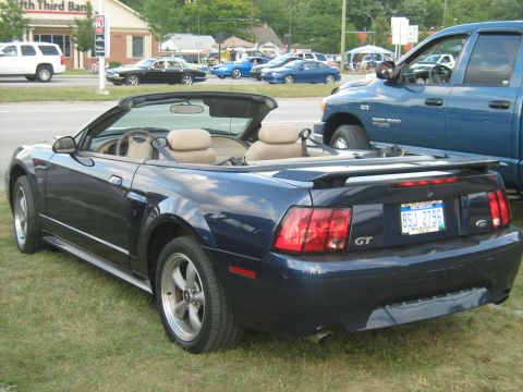 1988 Mercury Grand Marquis - Blue convertible sports car parked on grass next to a blue pickup truck.