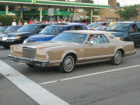 1988 Mercury Grand Marquis - A classic Lincoln Continental Mark V is seen in a line of vehicles, possibly at a car show or event.