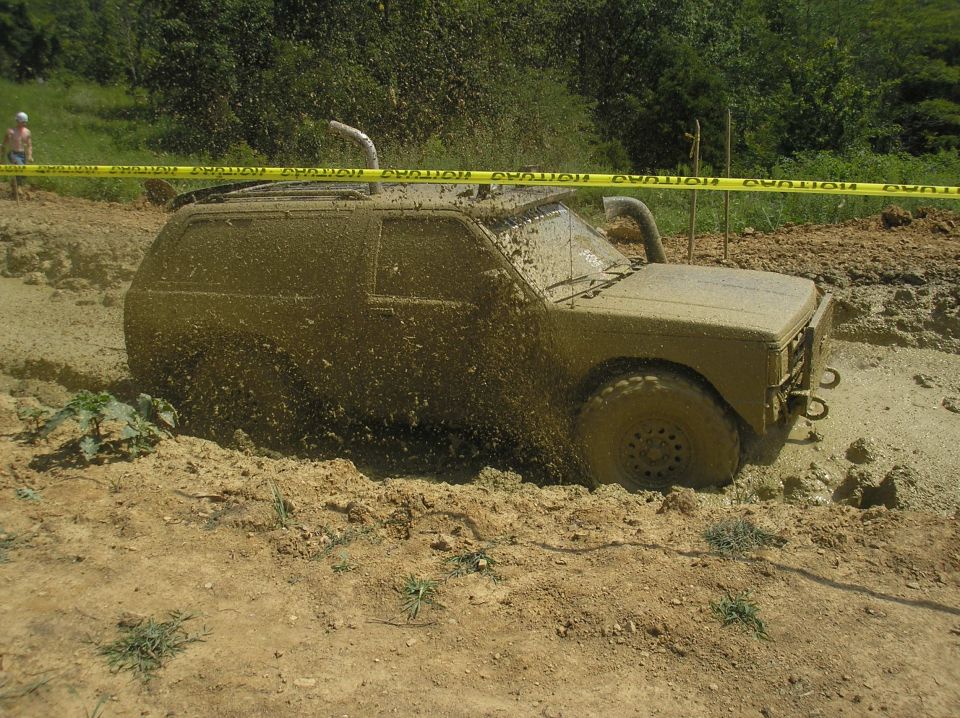 Muddy 2002 Ford Sport Trac stuck in a mud pit with snorkel and yellow caution tape