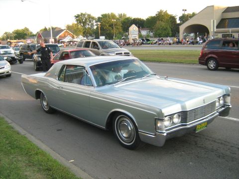 1988 Mercury Grand Marquis - A classic Mercury Cougar cruises down the road during a car show event.