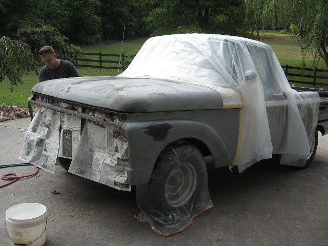 1966 Ford F-100 truck with hood and grille covered in plastic sheeting and newspaper