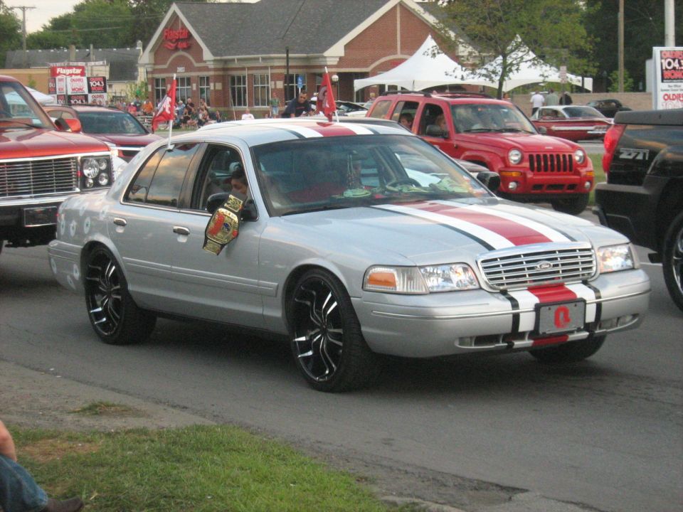Silver Ford Crown Victoria with red racing stripes on black rims