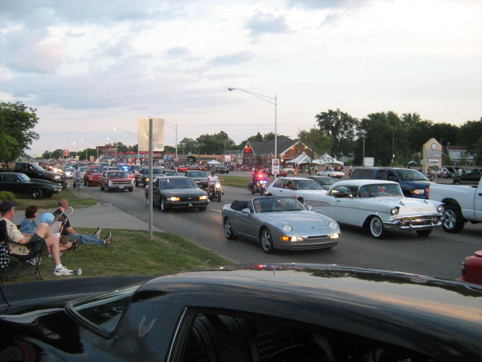 Silver convertible sports car in a cruise with other vehicles