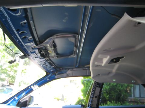 2007 Subaru Impreza - The interior roof of a vehicle is exposed, revealing its structural components and wiring beneath the headliner.