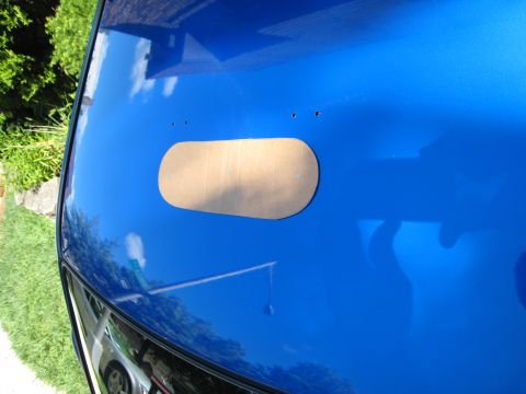 2007 Subaru Impreza - A cardboard template is taped to the hood of a blue car, likely for cutting a vent.