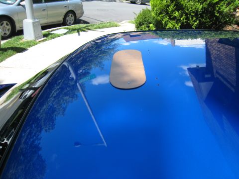 2007 Subaru Impreza - A cardboard cutout is placed on the shiny blue roof of a car.