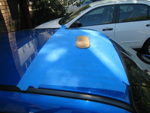 2007 Subaru Impreza - A blue car's roof is covered with blue painter's tape, with a small tan cutout placed on top.