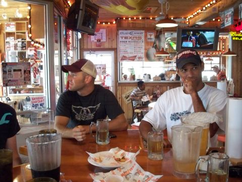 1996 Ford Bronco - Two men sit at a bar in a restaurant, with drinks and food on the table in front of them.