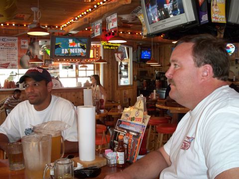1996 Ford Bronco - Two men are seated at a table inside a Hooters restaurant, with televisions visible in the background.