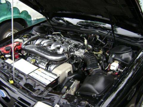 1991 Ford Taurus - The engine bay of a 1991 Ford Taurus, its V6 engine and various components.