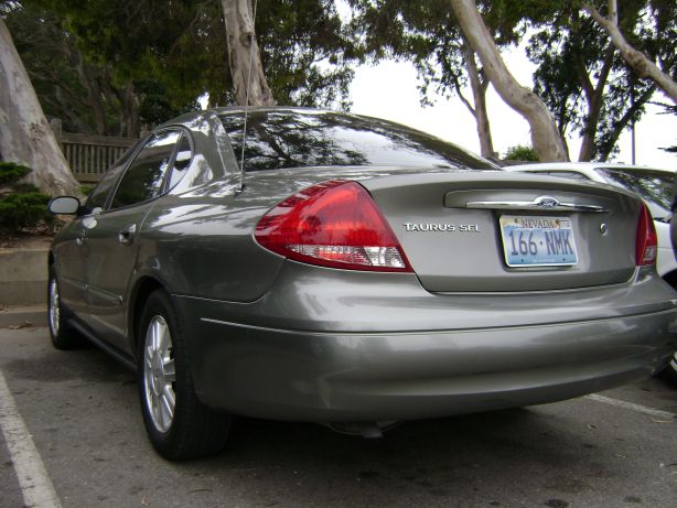 Gray Ford Taurus sedan, rear driver's side quarter view, Nevada license plate 166-NMK