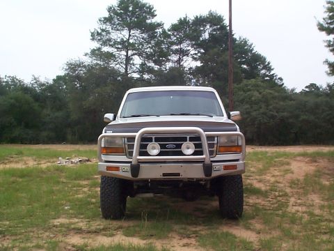 1992 Ford Bronco - This 1992 Ford Bronco is parked in a grassy area with trees in the background.